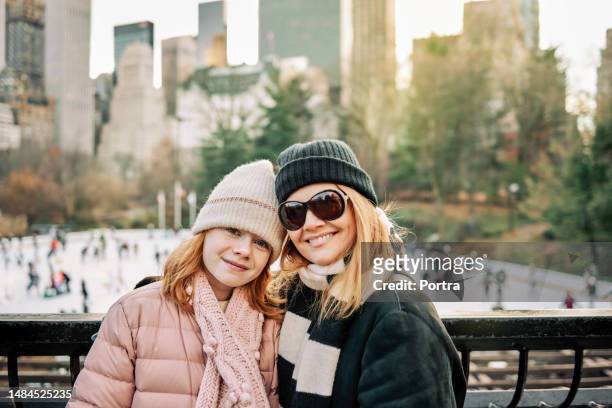 retrato de una hermosa madre e hija en invierno visten contra la pista de hielo en la ciudad - manhattan autumn fotografías e imágenes de stock