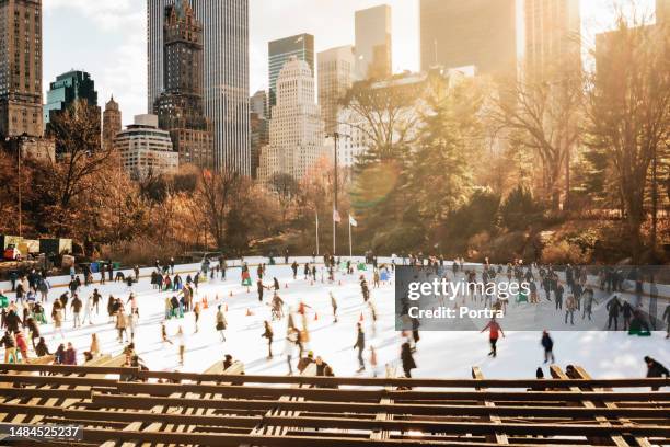 central park di new york city durante l'inverno con diversi pattinatori su ghiaccio - pista di pattinaggio su ghiaccio foto e immagini stock