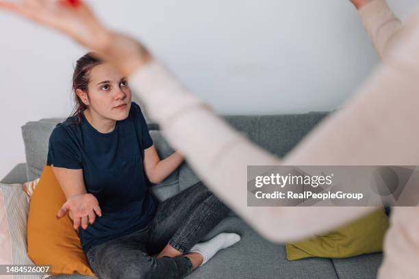 mother dealing with disobedient daughter in living room - clashes stock pictures, royalty-free photos & images