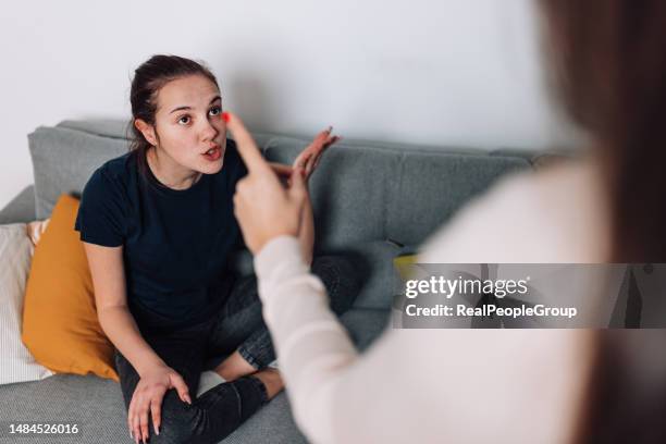 madre e hija trabajando a través del conflicto en la sala de estar - strict parent fotografías e imágenes de stock