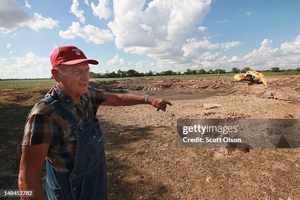 Marion Kujawa looks over a pond he uses to water the cattle on his farm on July 16, 2012 in Ashley, Illinois. Kujawa has been digging the pond deeper...