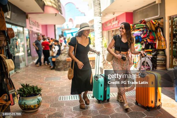 female traveler friends taking a walk around a local market outdoors - mexican street market stock pictures, royalty-free photos & images