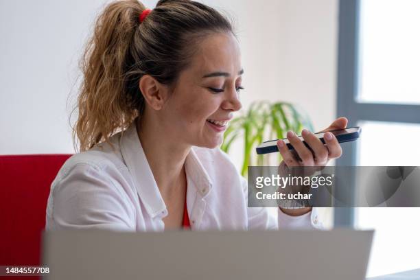 office worker woman holding mobile phone dictating voicemail using mobile messenger - diktera bildbanksfoton och bilder