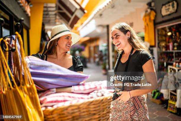 female traveler friends looking at merchandise on a local market outdoors - mexican street market stock pictures, royalty-free photos & images