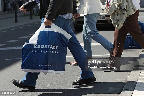 Shoppers walk with Karstadt department store shopping bags in Steglitz district on July 17, 2012 in Berlin, Germany. Karstadt management recently...