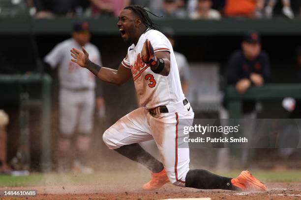 Jorge Mateo of the Baltimore Orioles celebrates after safely sliding into home plate for a run against the Detroit Tigers during the eighth inning at...