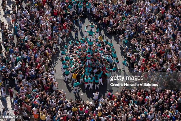 Large crowd of locals and tourists watch as Castellers de Vilafranca members climb on top of each other while building a "castell" by Padrão dos...