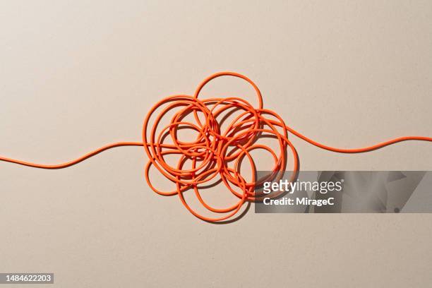 orange colored ropes tangled knot - object coloured background stock pictures, royalty-free photos & images