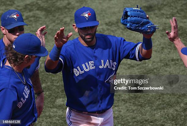 Jose Bautista of the Toronto Blue Jays is congratulated by Colby Rasmus Brett Lawrie and Kelly Johnson after making a defensive play to end the 8th...