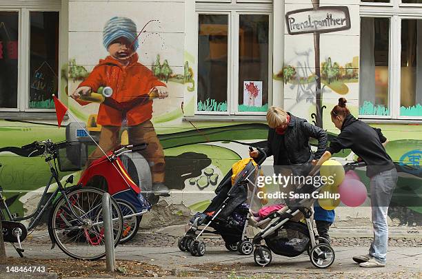 Two women with baby prams walk past a child day care center on July 17, 2012 in Berlin, Germany. The German government recently passed a new law that...