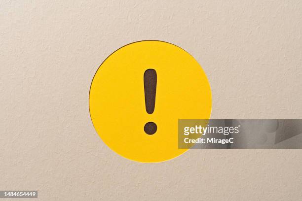 yellow exclamation point in a circle frame, paper craft - ausrufezeichen stock-fotos und bilder