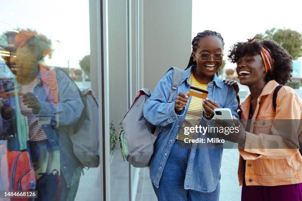 african american female friends using online banking  on smart phone - gen z shopping stock pictures, royalty-free photos & images