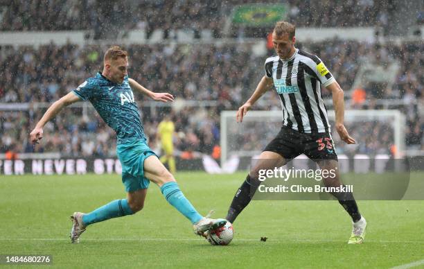 Dejan Kulusevski of Tottenham Hotspur is challenged by Dan Burn of Newcastle United during the Premier League match between Newcastle United and...