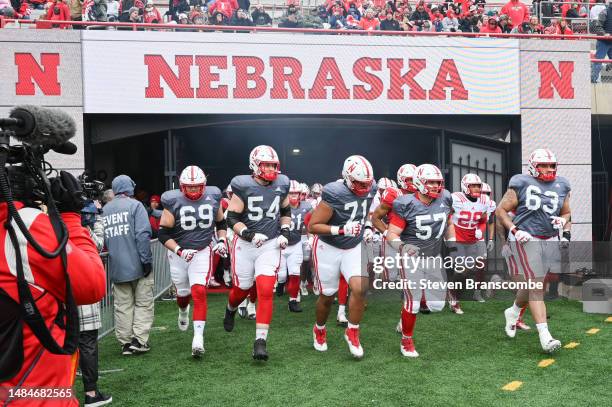 The offensive line of the Nebraska Cornhuskers take the field to warm up at Memorial Stadium on April 22, 2023 in Lincoln, Nebraska.