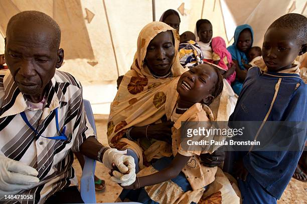 Girl cries after getting a malaria test in the out patient department at the MSF field hospital July 17, 2012 in Jamam refugee camp, South Sudan. Up...