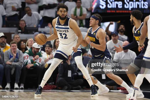 Karl-Anthony Towns of the Minnesota Timberwolves posts up against Aaron Gordon of the Denver Nuggets during the fourth quarter at Target Center on...