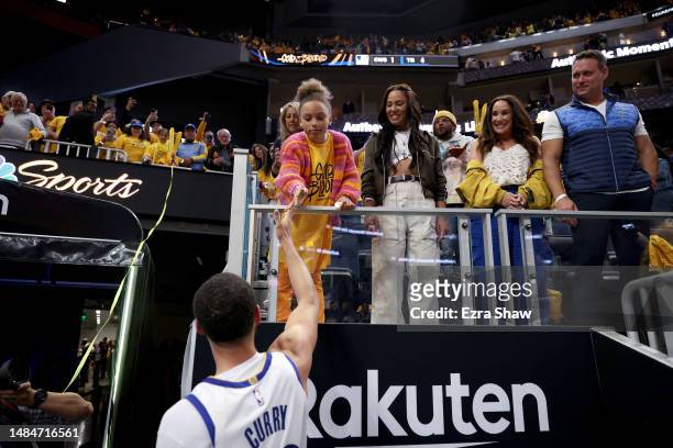 Stephen Curry of the Golden State Warriors shakes hands with his daughter, Riley Curry, after the Warriors beat the Sacramento Kings in Game Four of...