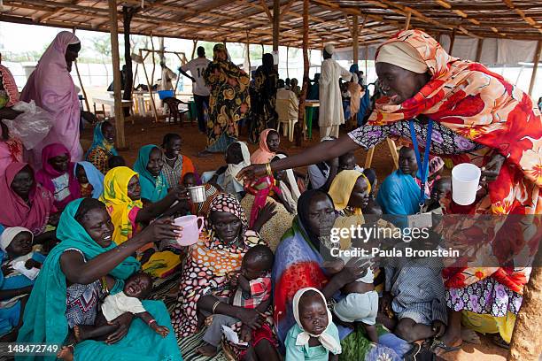 Sudanese mothers gather for a therapeutic feeding for their malnourished babies at the MSF field hospital July 17, 2012 in Jamam refugee camp, South...