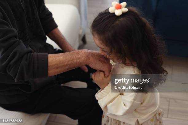 little girl kissing her grandfather hand and celebrating ramadan - kyssa på handen bildbanksfoton och bilder