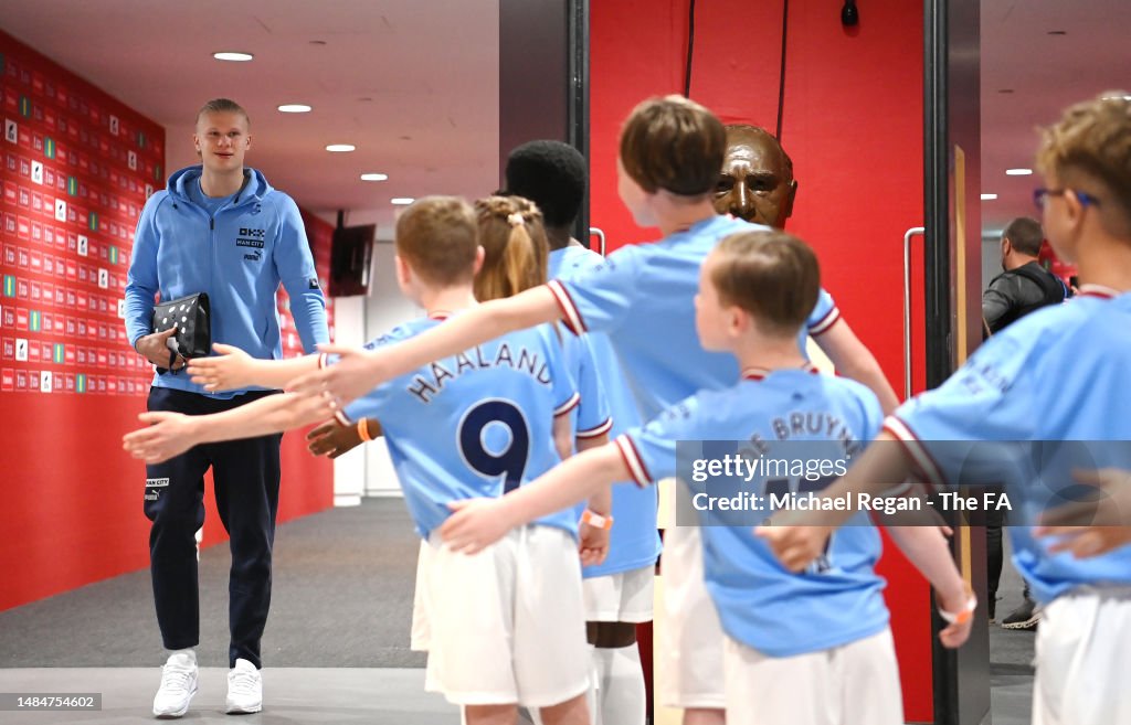 Erling Haaland is greeted by mascots as he arrives in the tunnel