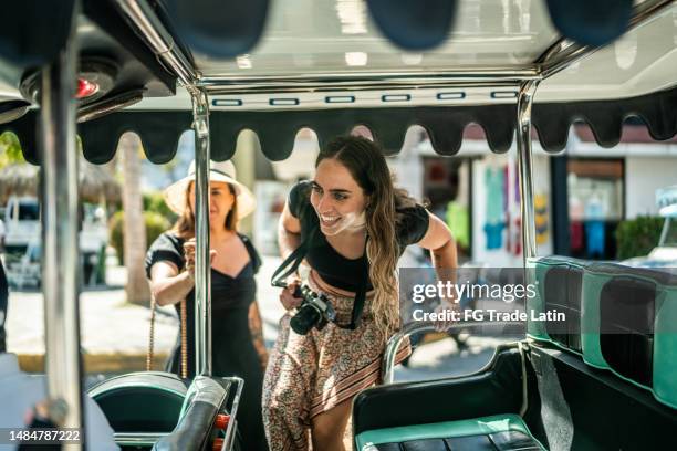 female traveler friends entering a local taxi - entering atmosphere stock pictures, royalty-free photos & images
