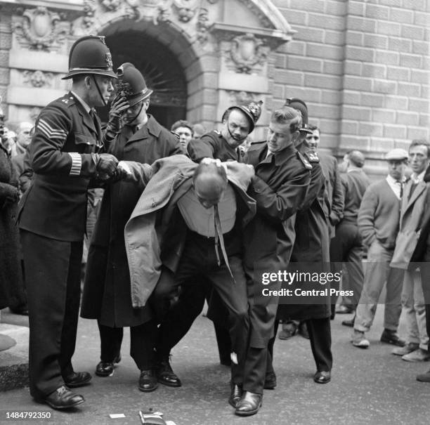 Jamaican singer Lucky Gordon being arrested by policemen outside the Old Bailey court building, London, April 1st 1963. The singer was arrested after...