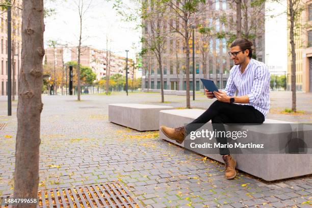 young businessman smiling and using his digital tablet - businessman full body isolated stock pictures, royalty-free photos & images