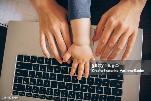 home office concept. mom and baby working on a laptop - busy mother stock pictures, royalty-free photos & images