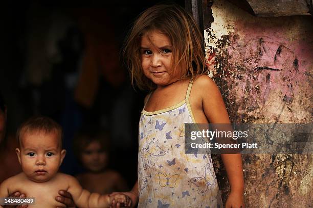 Child stands in the shack she shares with her family beside a dumpster in a gang infested neighborhood on July 17, 2012 in Tegucigalpa, Honduras. The...