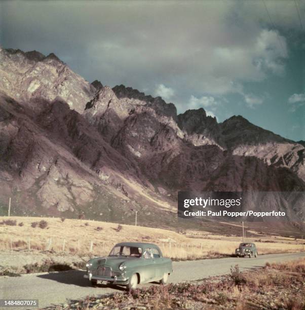 Car stops beside a road overlooked by The Remarkables mountain range near the town of Queenstown in the Otago region of the South Island of New...