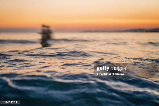 unrecognizable people enjoying sunset in the sea - women for wallpaper stock pictures, royalty-free photos & images