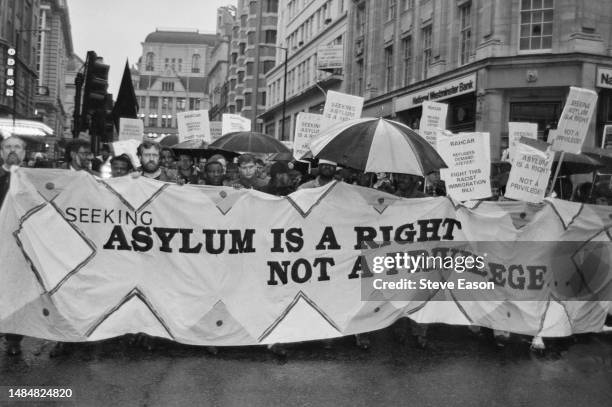 British politician, Jeremy Corbyn holding a banner during a demonstration organised by RAHCAR against the government's Asylum Bill, London, 21st...