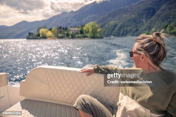 woman on vacation enjoys a boat ride o a lake - lago maggiore stockfoto's en -beelden