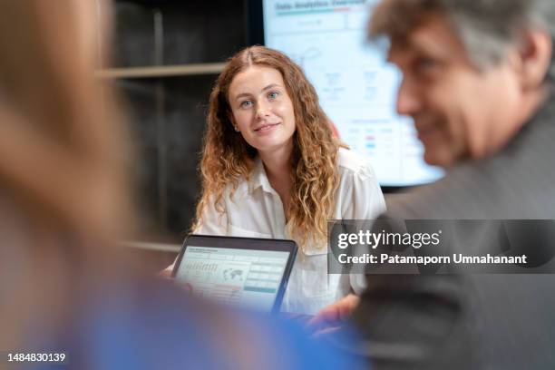 product launch incentives can take turns for business growth. businesswoman explain the strategic plan to launch the new product via digital table to sale team in the meeting room at office. brainstorming and share idea to launch new product to customer. - cost management stockfoto's en -beelden