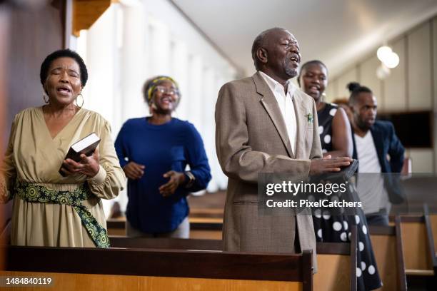 senior member of congregation singing in church - gospel music stockfoto's en -beelden