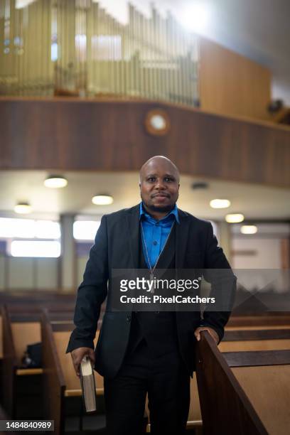 portrait pastor standing in church holding his bible - pastor stock pictures, royalty-free photos & images