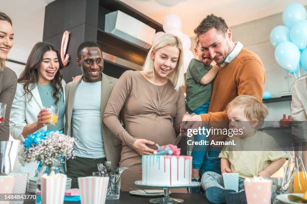 a mixed-race group of friends gathers for a joyous gender reveal party - gender reveal stock pictures, royalty-free photos & images