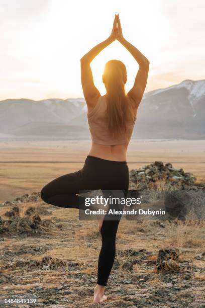 woman doing yoga in the mountains at sunrise - spiritual enlightenment stock pictures, royalty-free photos & images