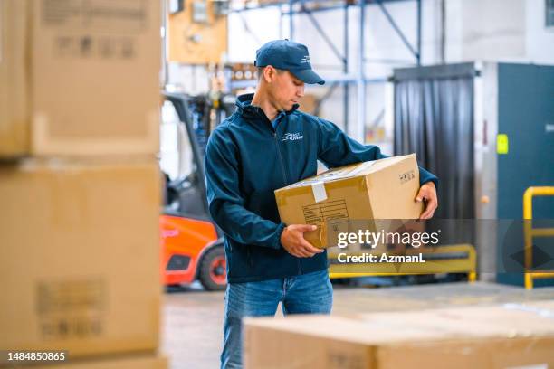 asian courier carrying a parcel - airplane hangar stock pictures, royalty-free photos & images