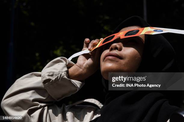 Student wearing solar eclipse glasses watching the hybrid partial solar eclipse in Bandung, West Java, Indonesia, April 20, 2023.