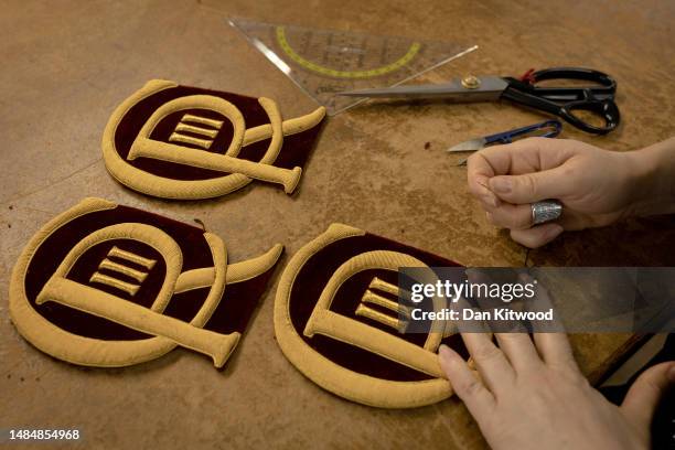 New CR III cyphers are cut out and prepared to be sewn onto ceremonial dress ahead of the Kings coronation, at Kashket & Partners on April 19, 2023...