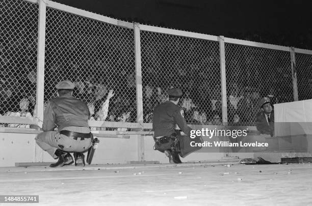 Police officers and a wire fence keep fans at bay during a Beatles concert at the Cow Palace in Daly City, near San Francisco, California, during...