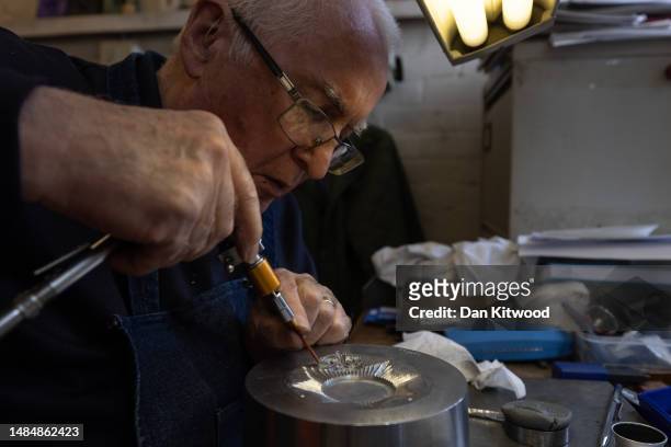 Master die sinker, Jim Baker, cuts a reverse of a tudor crown on a die for the new police helmet plates at Firmin & Sons on April 19, 2023 in...