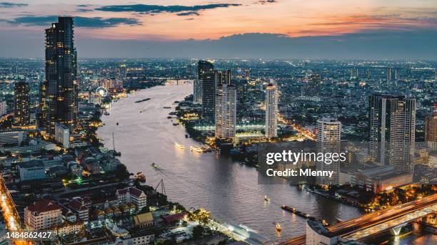 illuminated bangkok cityscape chao phraya river thailand sunset panorama - bangkok imagens e fotografias de stock