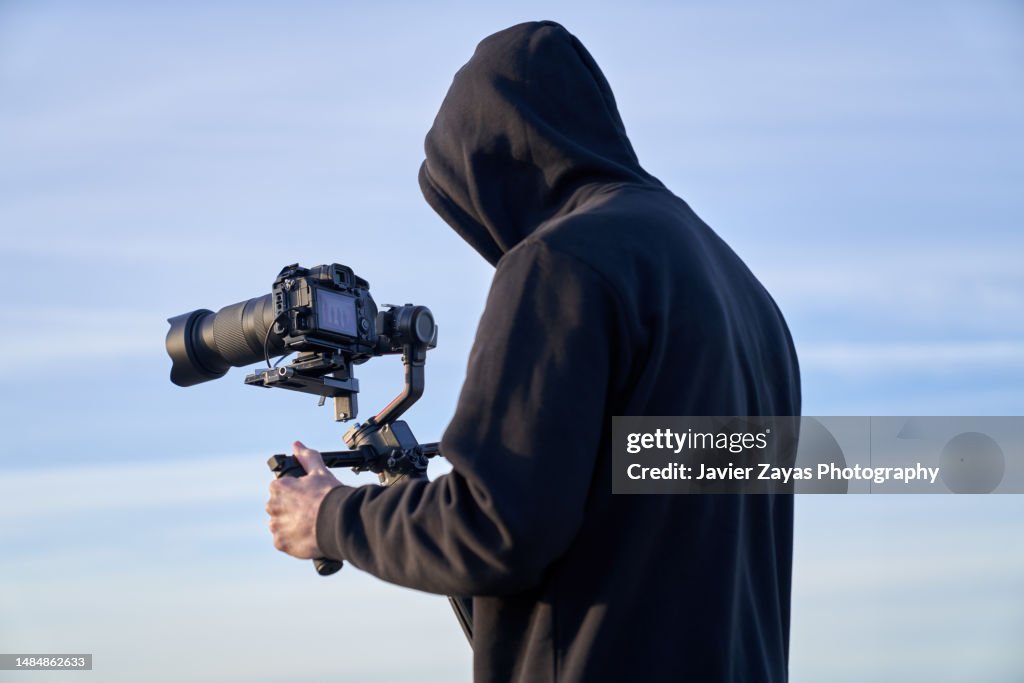 Camera Operators Outside Camera Operator Filming On The Beach Using A Stabilizer High-Res Stock ...