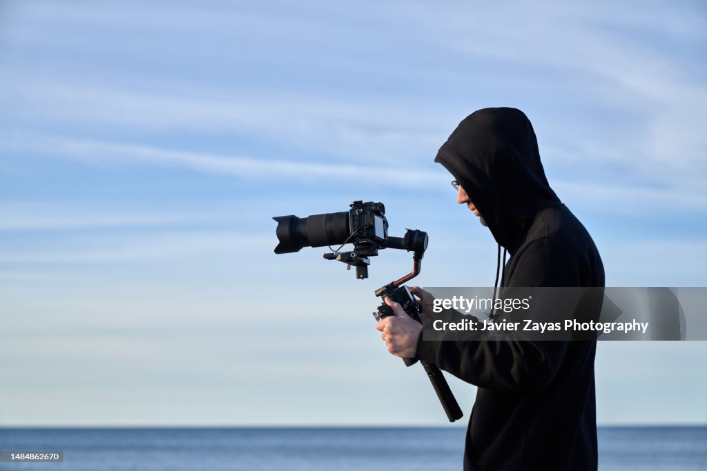 Camera Operators Outside Camera Operator Filming On The Beach Using A Stabilizer High-Res Stock ...