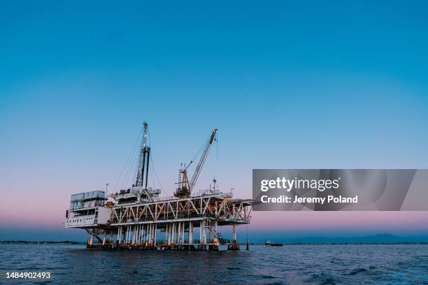 wide angle shot of an off-shore oil rig at dusk near huntington beach - opec stock pictures, royalty-free photos & images