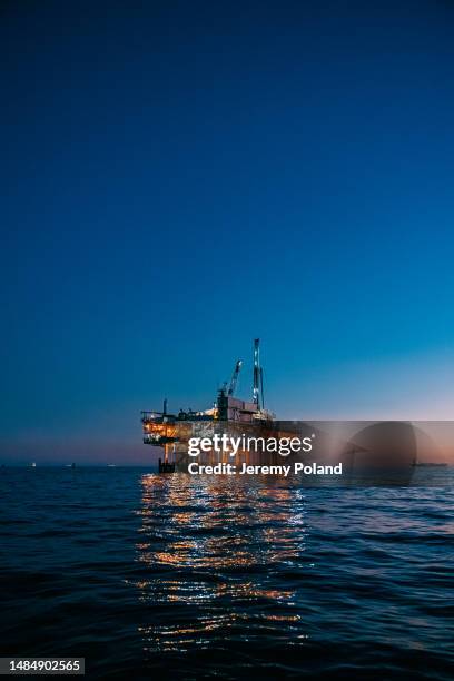 portrait of an offshore oil drilling rig at dusk near huntington beach with copy space - opec stock pictures, royalty-free photos & images