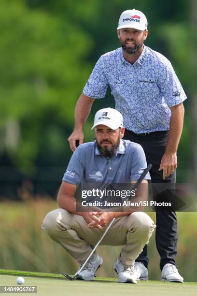 Troy Merritt and Robert Streb of the United States check the line before putting on the 18th green during the Final Round of the Zurich Classic of...