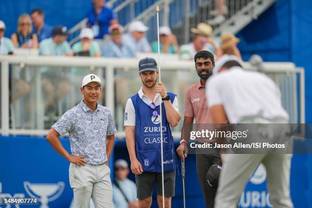 Justin Suh and Sahith Theegala from the United States wait as Hayden Buckley of the United States on the 18th green during the Final Round of the...